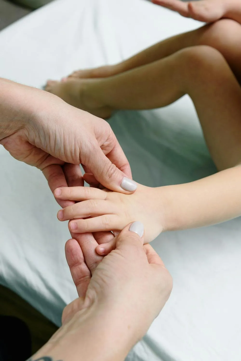 Ostéopathie pour enfant à Neuilly-sur-Seine, soin doux de la main lors d'une consultation